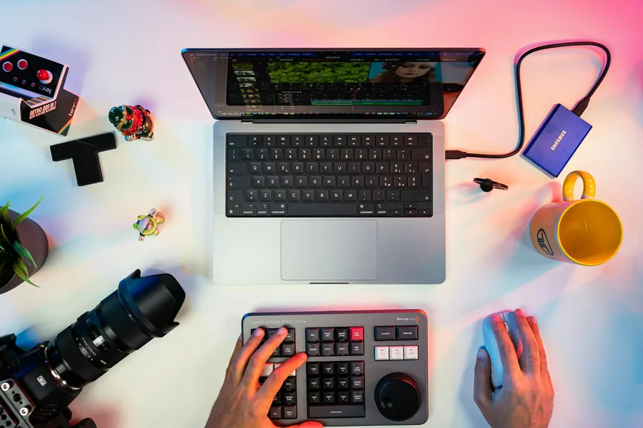 Laptop and keyboard on a white desk, from above